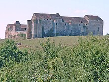 Photo d'un château médiéval au milieu d'un paysage verdoyant.