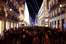 A crowded street with decorative lights.