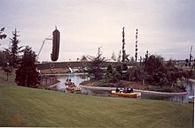 Photographie de deux attractions : une rivière avec des petites barques, et un bateau pirate géant se balançant.