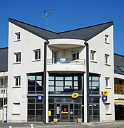 Bâtiment moderne à trois étages avec grande baie vitrée à l'entrée.