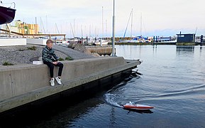 Un garçon conduit son bateau radiocommandé dans le port de plaisance de Ystad.