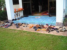 entrance to a building with many people's shoes scattered in front of the doorway