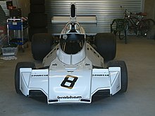 A mid-engined single-seater racing car with large aerodynamic wings