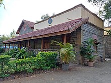 House made of stone and tiled sloping roof with garden in front