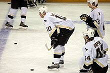 Photo de John Leclair dans le maillot numéro 10 des Penguins de Pittsburgh et devant deux coéquipiers dont le numéro 44 Brooks Orpik.
