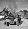 Az SS „Totenkopf” hadosztály katonái menet közben pihenőt tartanak egy égő faluban, 1941. nyara