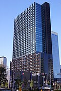 北東側からの新宿グランドタワー。右に接して建つフロントタワー。赤信号に重なる2階建はグランドウィング。その奥の中層建物がグランドプラザ。12年3月12日撮影