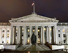 A photograph of the US Treasury Building at night