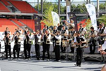 Un groupe de musiciens en costume breton traditionnel joue dans un stade.