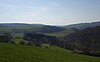 Blick von etwas oberhalb von Wüstems nach Westsüdwest auf den Isberg, die wiesenbewachsene Erhebung im Bildmittelgrund