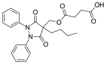 Two-dimensional monochrome diagram showing the structure of the molecule of Suxibuzone, uing the hexagonal style to depict a chemical compound.