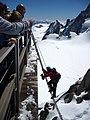 Alpine climbers on the Cosmiques Ridge use a metal ladder to regain access to the 'Midi station'