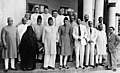Indiske muslimar frå All India Muslim League Working Committee i 1940. Ei kvinne har på seg heildekkande burka. Mennene har på seg tradisjonelle muslimske drakter og luer eller vestlege dressar.