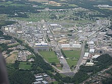 Aerial photograph showing a large industrial area, including a number of laboratory buildings (some with chimneys), roadways, and recreational areas