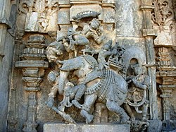 Relief Bima bertarung melawan Bagadata (menaiki gajah perang) dalam suatu ukiran di Belur, India.