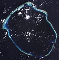 A 2002 true-color photograph of Enewetak Atoll. The relatively large Ivy Mike crater can be seen at the top of the atoll in this image with the smaller, adjoining Castle Nectar crater, in close proximity. The much smaller Redwing Seminole crater can faintly be seen on Bogon Island.