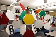 Brightly colored stacked truncated octahedrons with children's faces in the openings