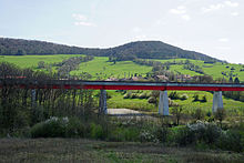 Photo couleur d'un viaduc. En arrière plan des collines.