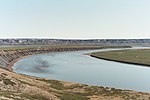 A big river winds across a plain near a bluff.