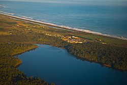 Ruatapu, with Lake Mahinapua shown in the foreground, and the Tasman Sea in the background.