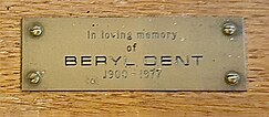 A brass plaque on the bishop's chair, situated close to the altar in the Church of St Mary the Blessed Virgin, Sompting, bearing a memorial to Dent with the following inscription: "In loving memory of BERYL DENT 1900 – 1977".