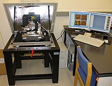 Picture of an atomic force microscope on the left with controlling computer on the right