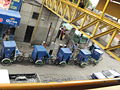 line of bicycle taxis waiting for business on Horacio Zuñiga Street just outside the Metro Los Reyes station