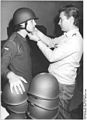 1990年、ヘルメットの支給を受ける連邦軍兵士。三点式の顎紐が明瞭に写っている。