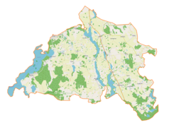 Mapa konturowa gminy Miłki, po lewej znajduje się owalna plamka nieco zaostrzona i wystająca na lewo w swoim dolnym rogu z opisem „Jezioro Jagodne”