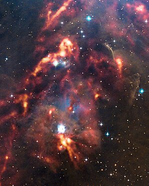 La région d'Orion : les nuages de poussière observés par APEX (en orange) sont superposés à une image dans le visible