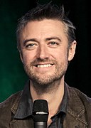 Sean Gunn interprète Kirk Gleason.