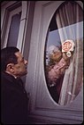 Anthony Bruno affixes a protest sticker to the front door of his Neptune Road House while Joseph Porzio looks on. (May 1973)