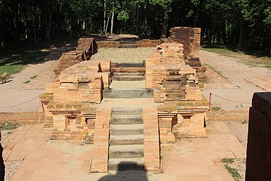 Mỹ Sơn G1, mi-XIIe siècle[38]. Escalier du gopura. Au delà, dans l'axe : mandapa, salle probablement protégée par une charpente couverte en tuiles