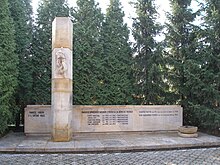 Kamenný památník (ve tvaru ležatého kvádru) uctívající oběti německé okupace stojící na nízkém vydlážděném podstavci v zátiší před jehličnatými stromy. V levé části pomníku je před pomník vystupující kameninový pilíř (dosahující asi trojnásobné výšky oproti ostatním prvkům pomníku), na kterém je plastika sepnutých rukou. Vlevo před památníkem je na kameninové základně kameninová miska.