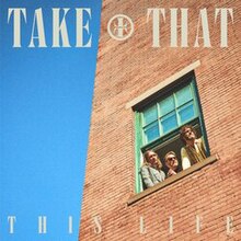 The three band members looking out of a window with the text 'TAKE THAT' above them and 'THIS LIFE' beneath