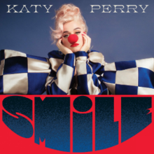 Katy Perry dressed as a sad clown wearing a giant bow, with the album title written under.