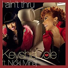 A portrait of two women laughing, sitting in a motor vehicle furnished in beige leather seating. The women are wearing red jackets with black shirts underneath. The portrait is bordered in red, the title 'I aint thru' appears in the top left-hand corner while 'Keyshia Cole ft. Nicki Minaj' appears in the bottom left-hand corner.