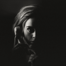 Foto hitam putih dari Adele yang sedang menggenggam sebuah telepon.