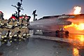 US Department of Defense fire fighters training on an aircraft carrier aircraft fire.