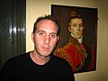 Richard Butler standing in front of a portrait of his ancestor, the Duke of Wellington