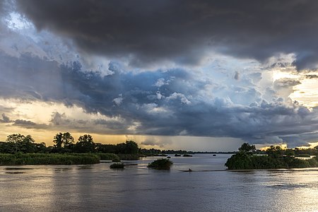 "Blue_and_orange_clouds_over_the_Mekong_with_a_pirogue_running_in_the_water_at_sunset_in_Don_Det_Laos.jpg" by User:Basile Morin