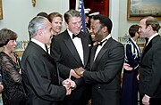 President of the United States Ronald Reagan with soccer player Pelé and President of Brazi José Sarney during a state dinner in The Blue Room, White House (10 September 1986)