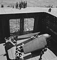 Navy crewmen aboard the Independence-class light aircraft carrier USS Monterey (CVL-26) pushing a Grumman F6F Hellcat fighter to the flight deck elevator in June 1944.