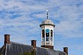 zicht op de klokkentoren en schoorsteenpijpen.