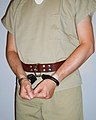 Handcuffs secured with a leather transport restraint belt.