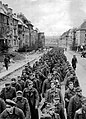 The endless procession of German prisoners captured with the fall of Aachen marching through the ruined city streets to captivity