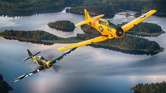 Finnish Air Force Hawker Hurricane warbird and US Navy T-6 Texan warbird in flight over Finland