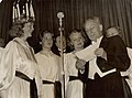 Szent-Gyorgyi (1893-1986) Nobel Prize-winning biochemist, stands with the queen of the Santa Lucia feast, possibly announcing her winning the contest. Caption reads: "Most beautiful girl & most glamorous man. Crowning of Santa Lucia feast in Stockholm. Beauty queen elected. Stockholm 1937. Nobel Prize." St. Lucia's day, December 13th, starts the Christmas season in Sweden, just after Nobel Prize day, December 10th.