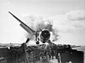  Crash landing of F6F on flight deck of USS ENTERPRISE while enroute to attack Makin Island. Lt. Walter Chewning, catapult officer, clambering up the side of the plane to assist pilot, Ens. Byron Johnson, from the flaming cockpit. November 1943.