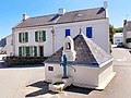 Le puits de Locmaria à Belle-Île-en-Mer. Ce puits se trouve en haut de la place de Méaudre, dominant l'église. Il est abrité dans un édicule carré coiffé d'un toit pyramidal en ardoise. Dans une niche perchée au bord du toit, une Vierge surveille la pompe peinte en bleu qui actionne ce puits.